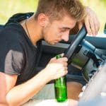 Man Holding Alcohol Bottle While Driving