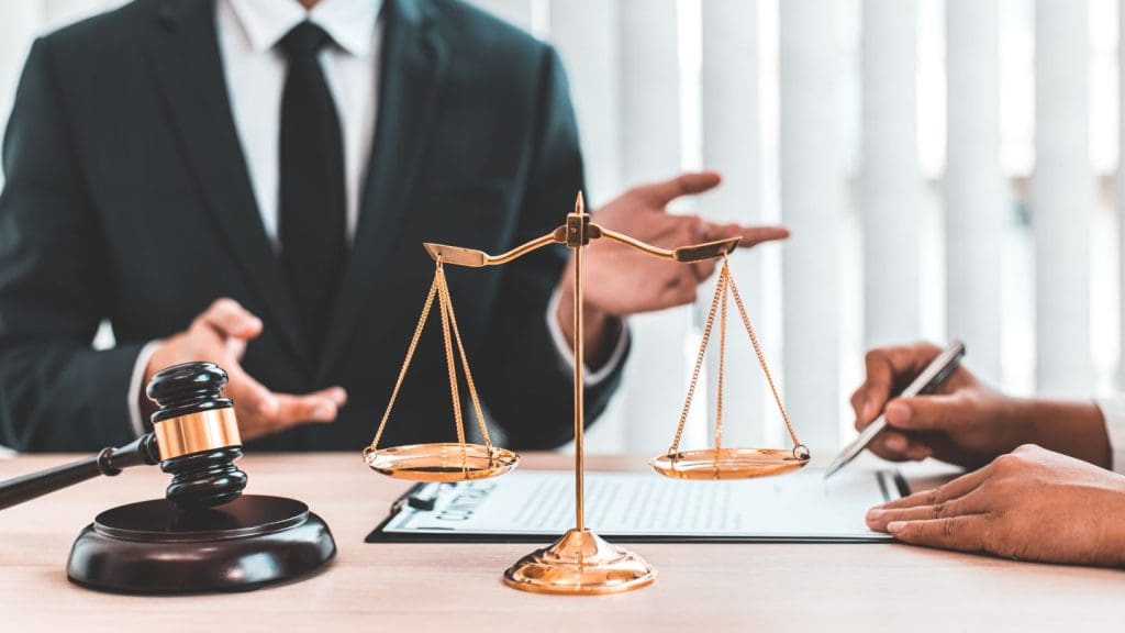 Scale Of Justice And Gravel On Lawyers Desk